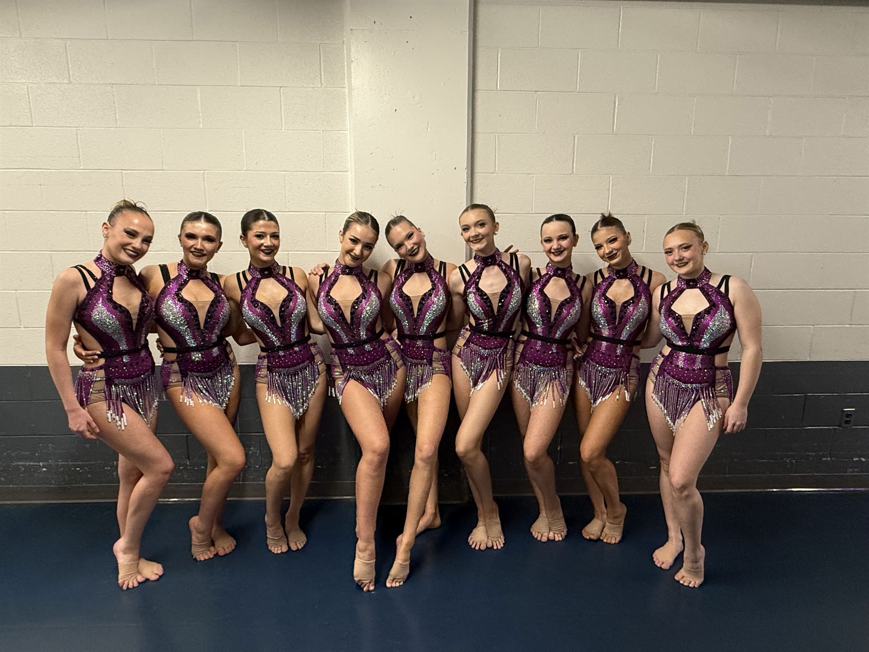 Dance team wearing coordinated purple costumes